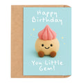 A cute birthday card with a kraft envelope, featuring a smiling little cupcake character on a light blue background with the text 'Happy Birthday You Little Gem!'.